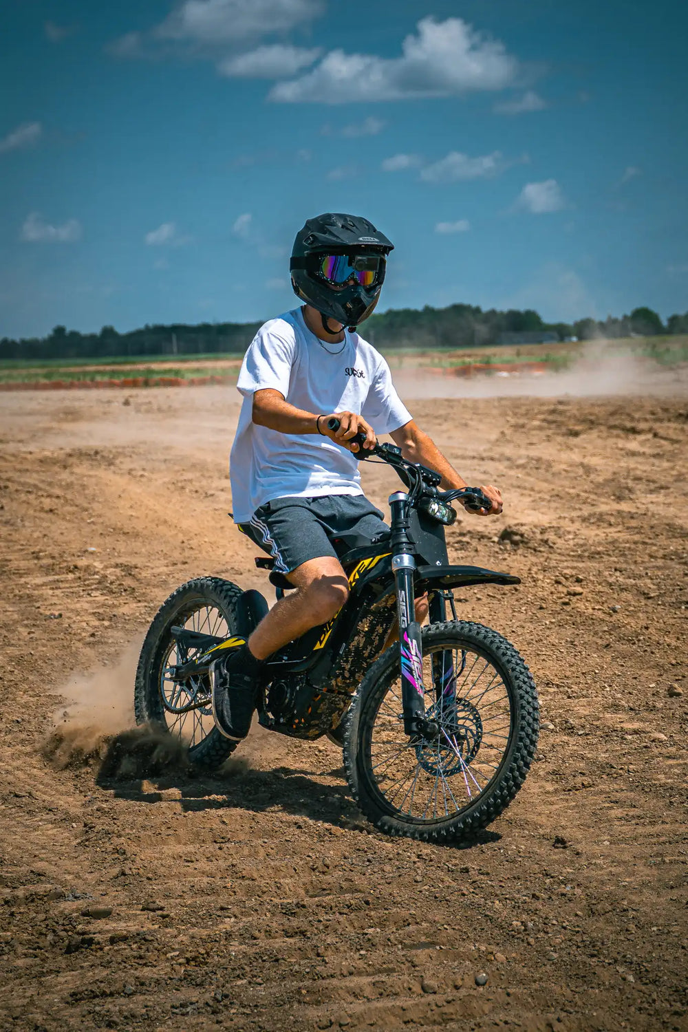 Adult enjoying offroad cruising on ThunderWasp XR16 responsive braking electric E-Moto in open dirt field