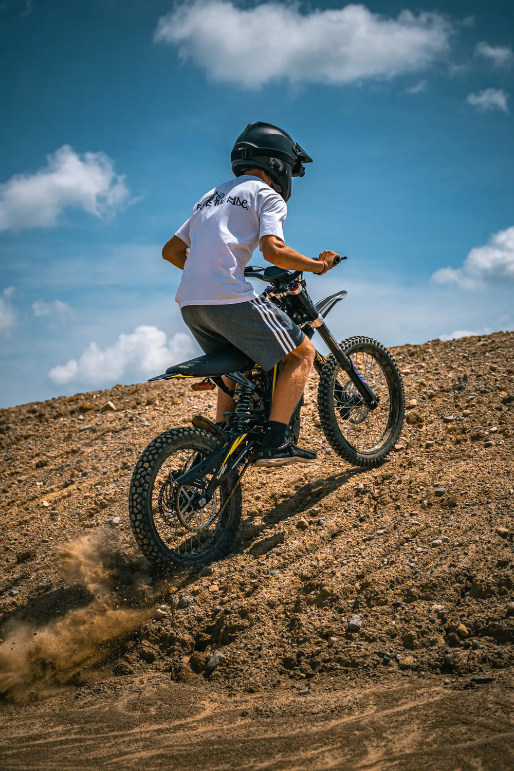 Adult enjoying offroad cruising on ThunderWasp XR16 responsive braking electric E-Moto in open dirt field