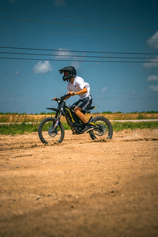 Medium close shot of rider adjusting fully tunable controller on XR16 offroad electric motocross